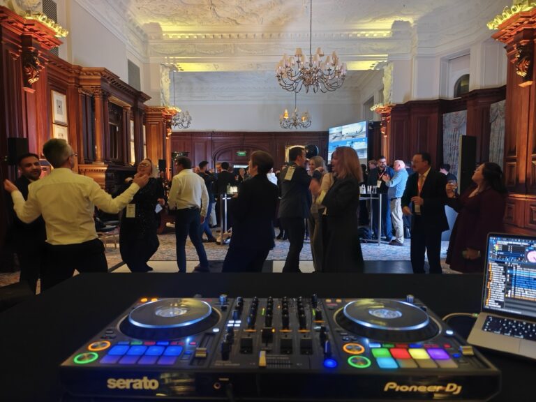 Guests gathered near the DJ booth during a corporate event at the Landmark London