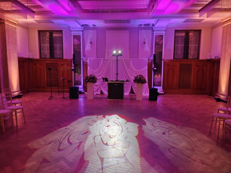 Event production by Party Night London: DJ booth with uplighting and a gobo projected onto the dancefloor