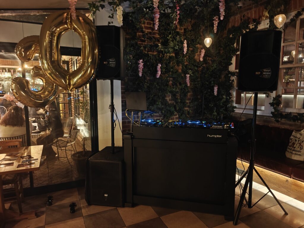 Gold balloons and DJ booth at a 30th birthday party at Saint & Sinner